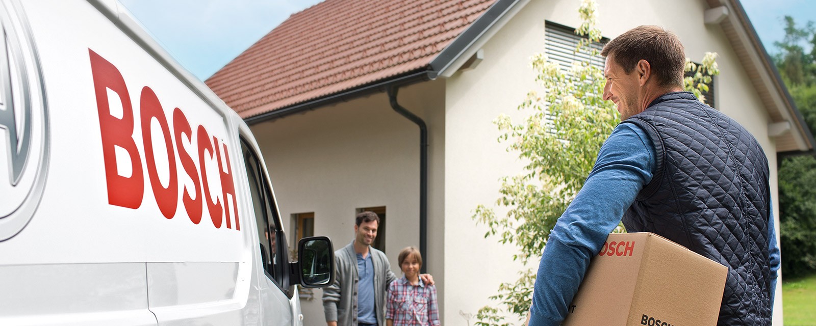 Installateur trifft bei einer Familie ein, um deren Wärmepumpe nachzurüsten.