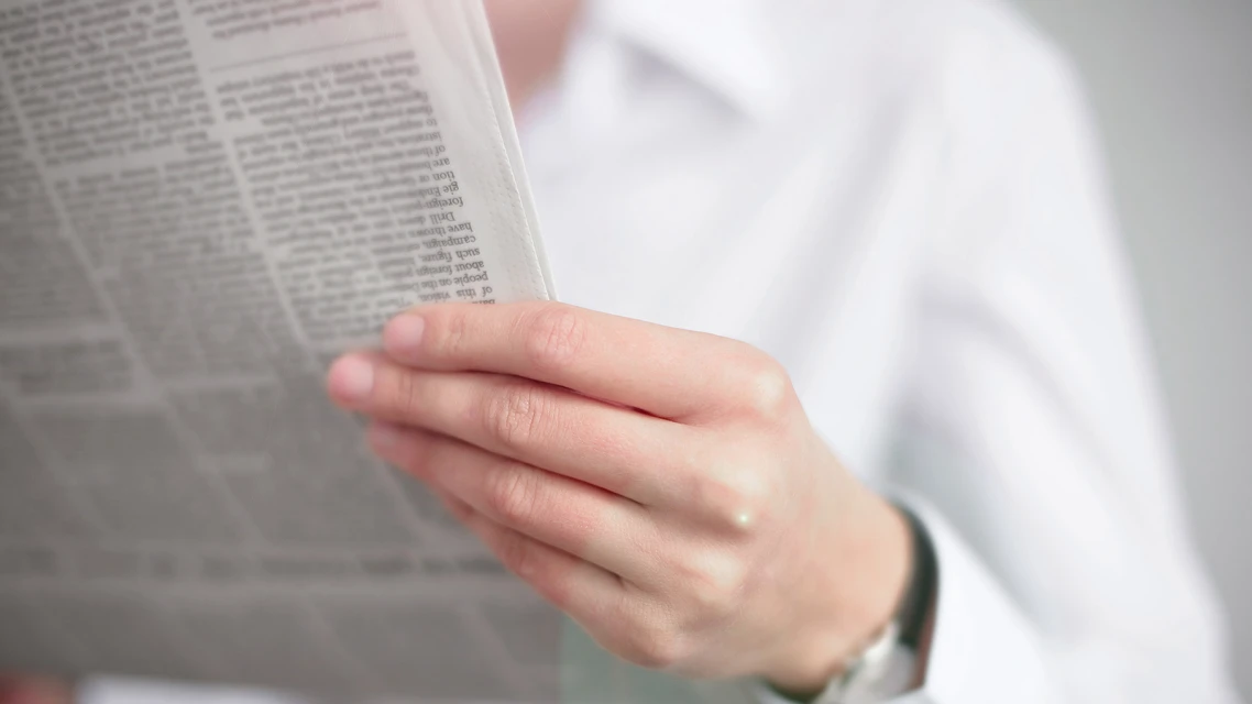 person reads a newspaper