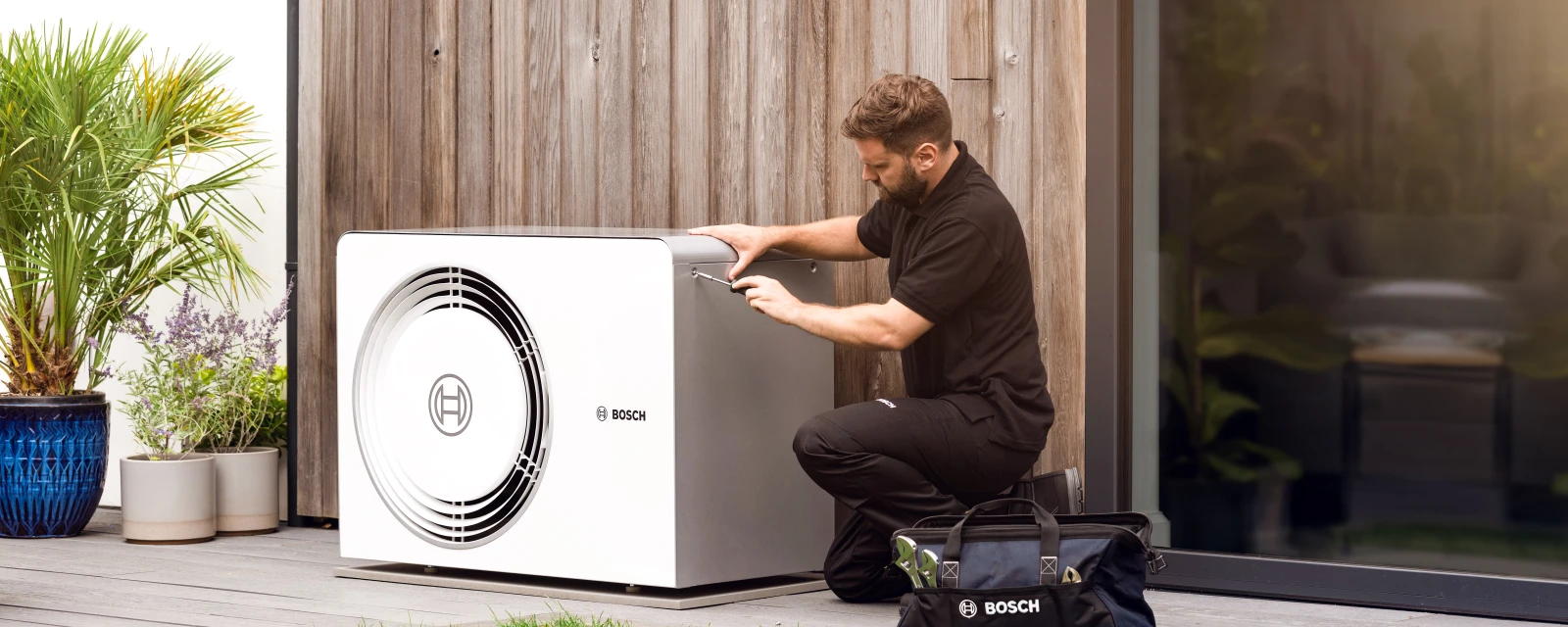 installer in front of bosch heat pump