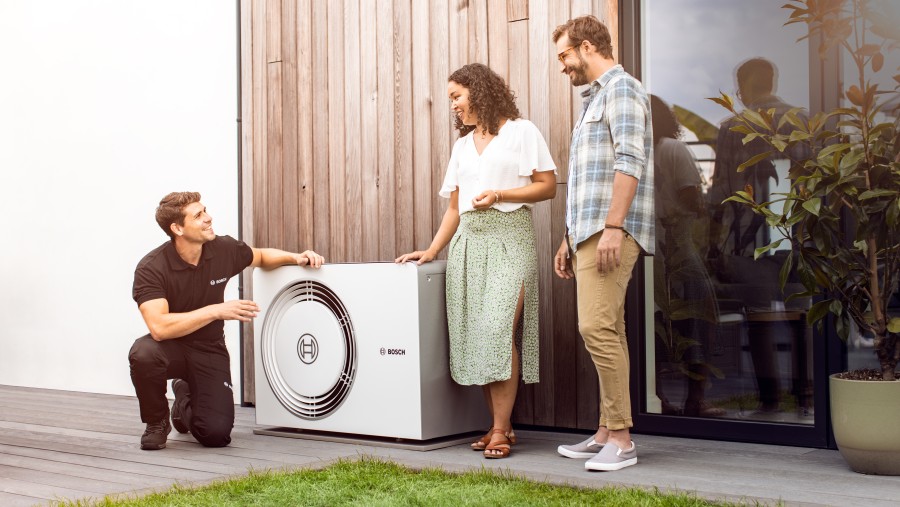 couple and installer standing by heat pump couple and installer standing by heat pump