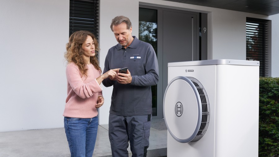 bosch installer with customer in front of heat pump bosch installer with customer in front of heat pump
