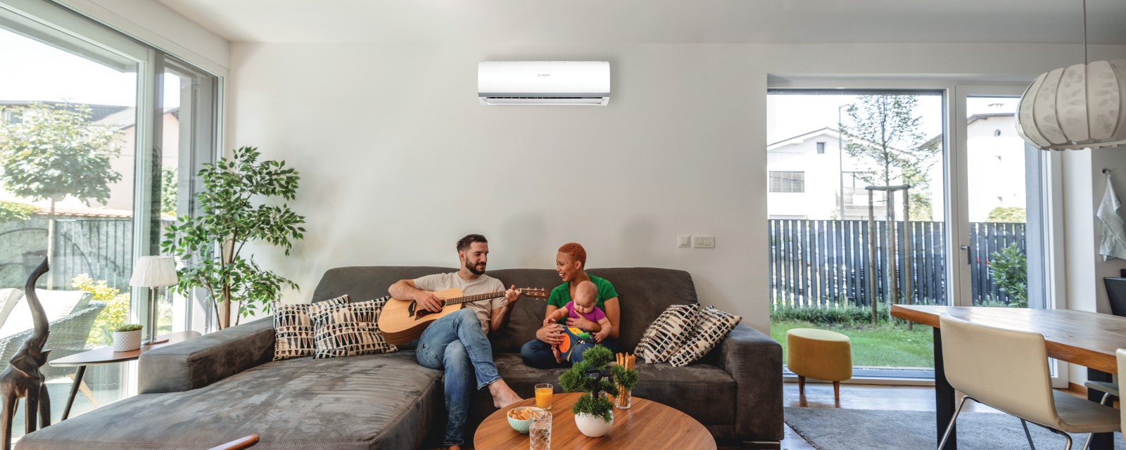 Familie auf dem Sofa mit Klimagerät Familie auf dem Sofa mit Klimagerät