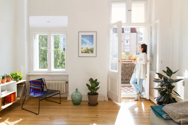 Woman standing in open balcony door
