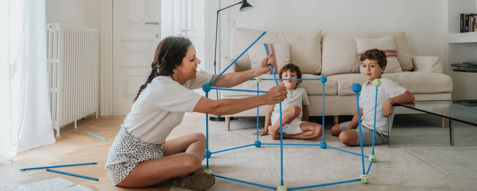 Frau mit Kindern beim Heizkörper