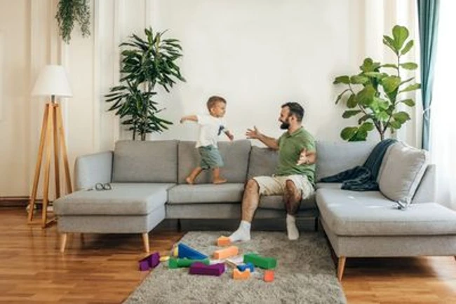 Mann mit Kind genießt die kühle Wohnung