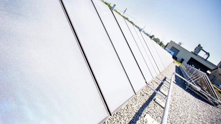 Solarkollektoren sind auf einem Flachdach installiert.