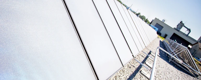 Solar collectors are installed on a flat roof.