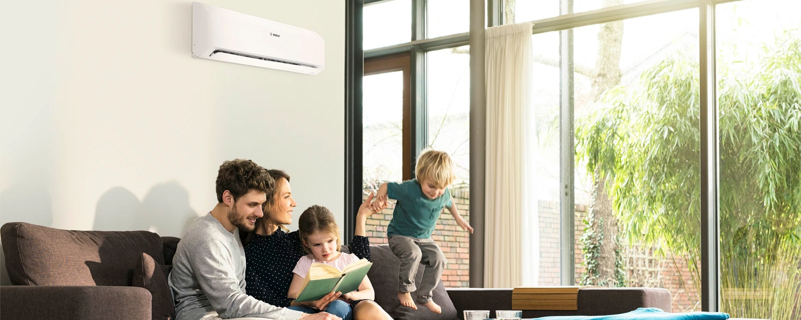 Family sitting on the sofa in front of an air conditioning system