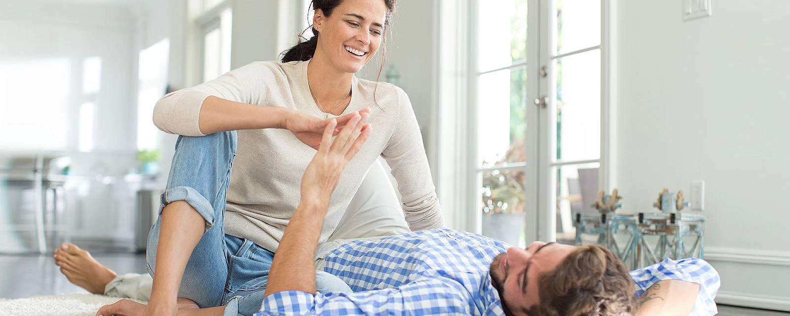 Woman and man sit on the floor and enjoy the warmth of the underfloor heating.