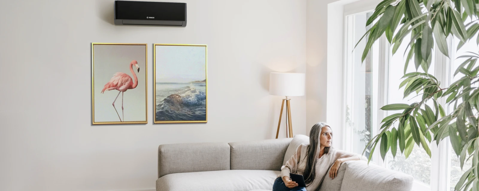 Woman sitting on a couch in front of an air conditioner.