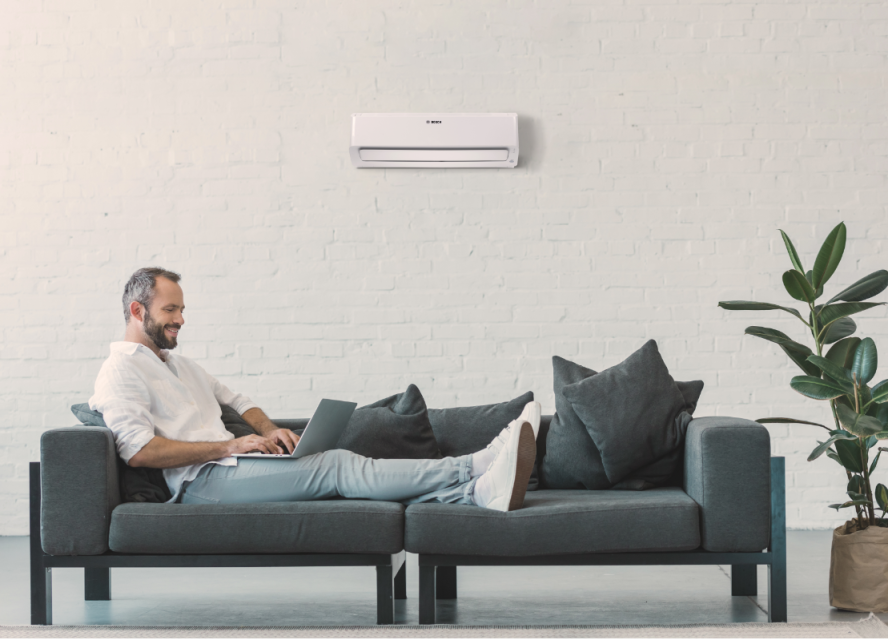 Man sitting on a sofa in front of an air conditioner Man sitting on a sofa in front of an air conditioner