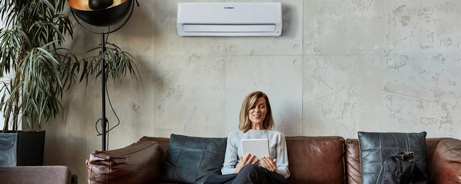 Woman sitting on a sofa in front of an air conditioner
