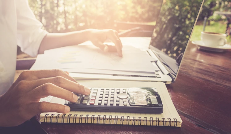 Iemand berekent de kosten van een warmtepomp met een rekenmachine