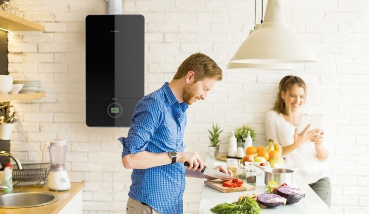 Een koppel in de keuken met een gasboiler op de achtergrond