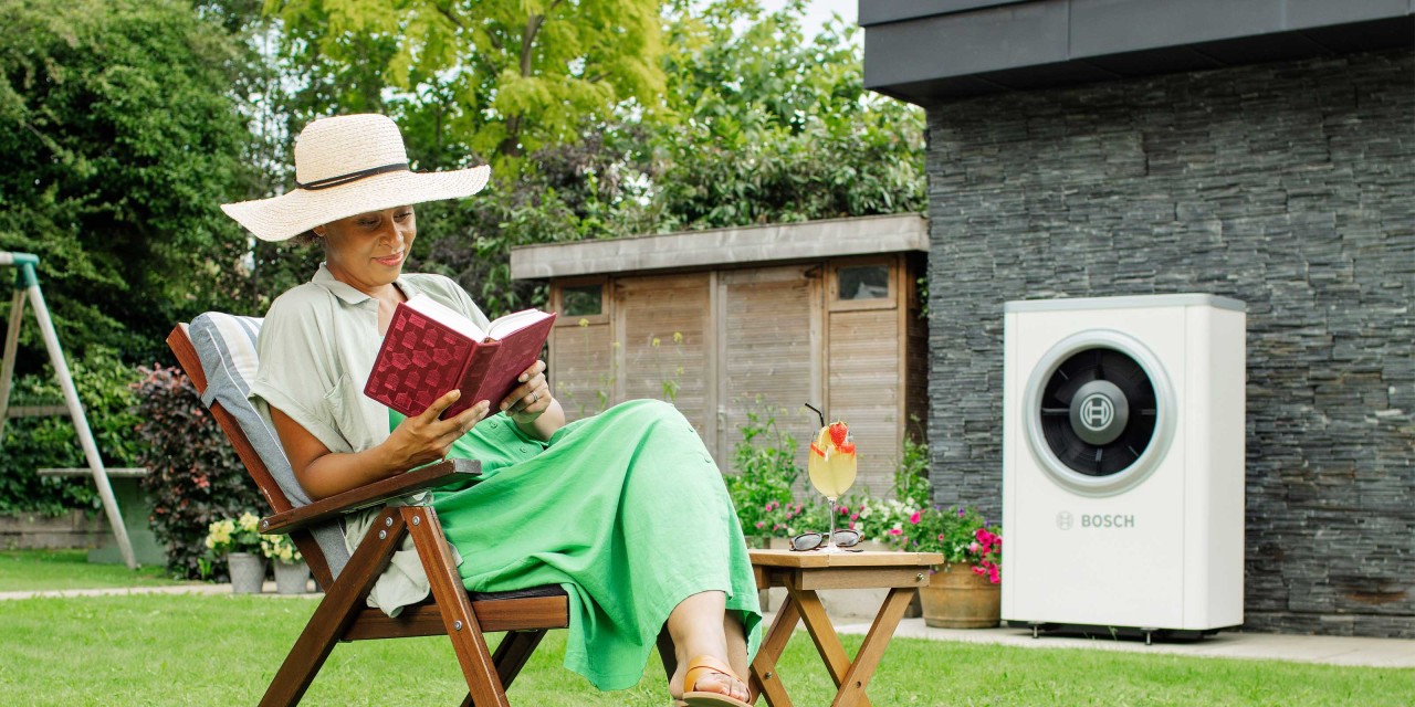 Vrouw bij buitenunit warmtepomp