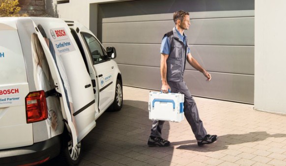 Un installateur arrive pour faire l'entretien chez un client Bosch ou Junkers Un installateur arrive pour faire l'entretien chez un client Bosch ou Junkers