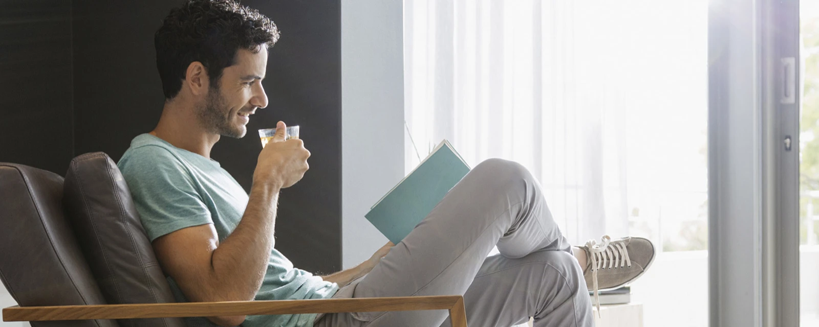 man leest en drinkt thee