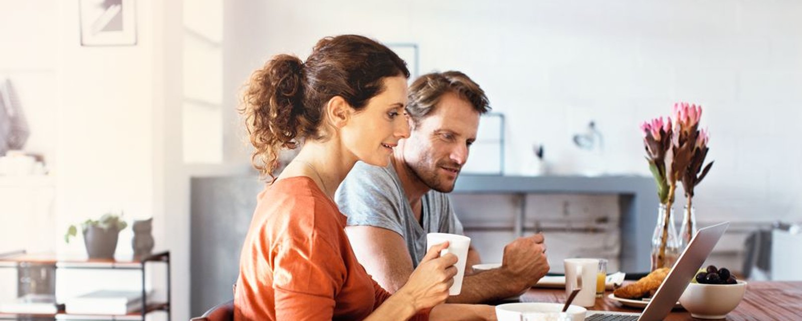 Koppel met laptop aan de keukentafel