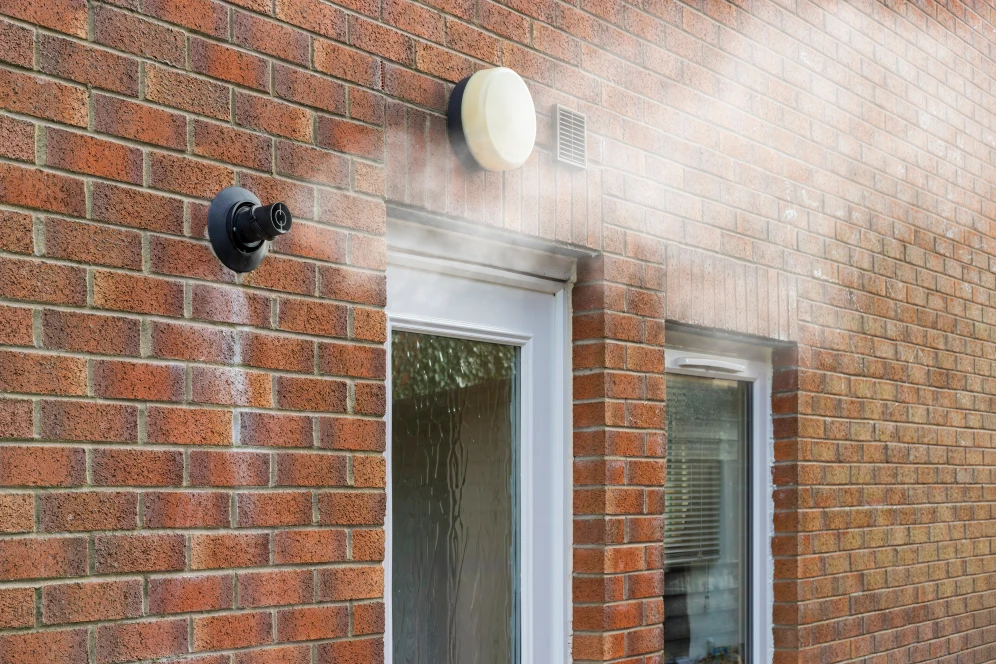 Rookgasafvoer naast een deur