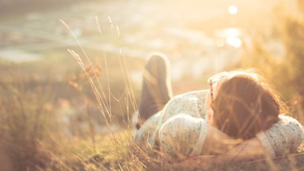 Persoon die in het gras van de zon aan het genieten is.