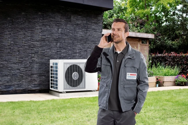 Bosch installateur met daarachter een Compress 3400i ODU.