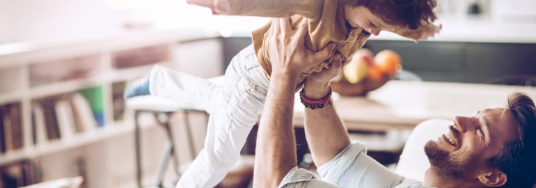 Vader die zijn kind aan het vasthouden is.