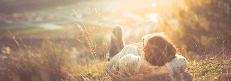 Persoon die in het gras van de zon aan het genieten is.