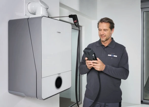 Un technicien fait l'entretien sur une chaudière à gaz