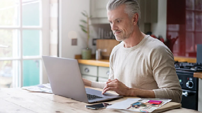 Un homme assis à un bureau suit la formation en ligne Bosch