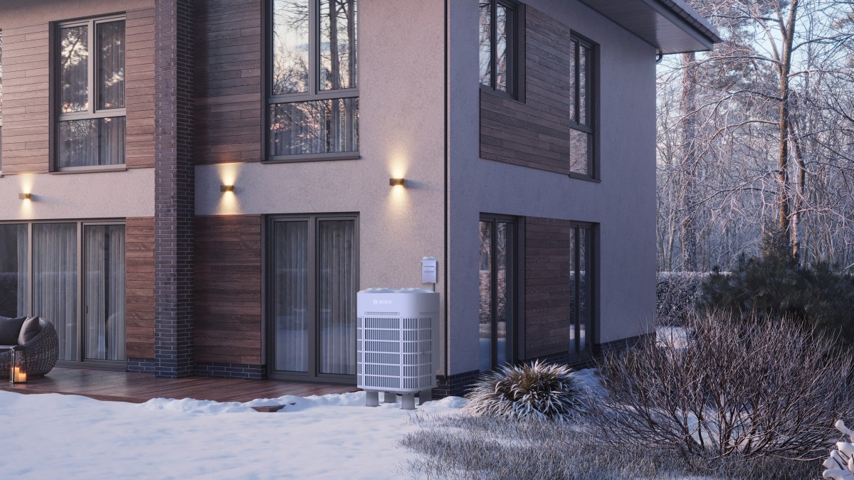 A Bosch IDS Ultra cold climate heat pump sits outside a modern home on a snowy day.