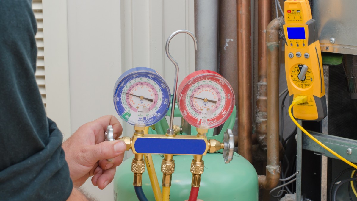 HVAC tech with refrigerant gauge