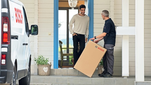 installer arrives at house with a box containing a boiler