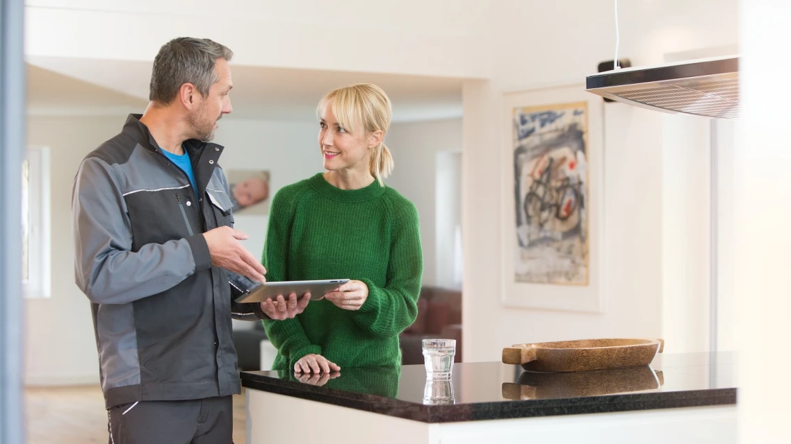 Un idraulico istruisce una donna sul funzionamento di una pompa di calore
