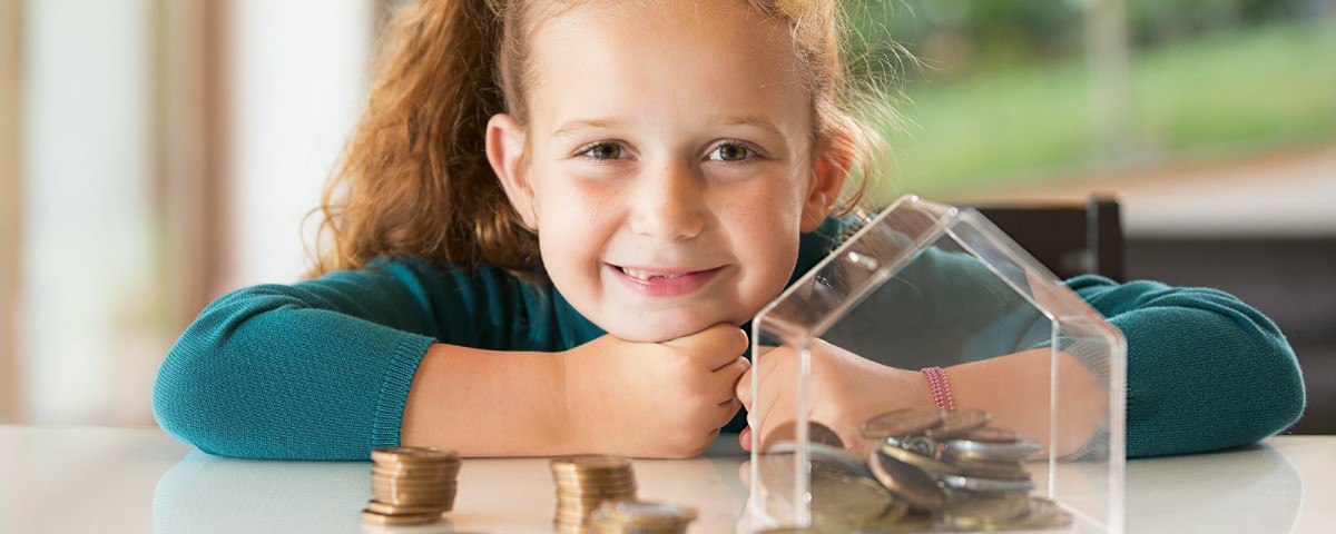 girl sitting in front of a money box girl sitting in front of a money box