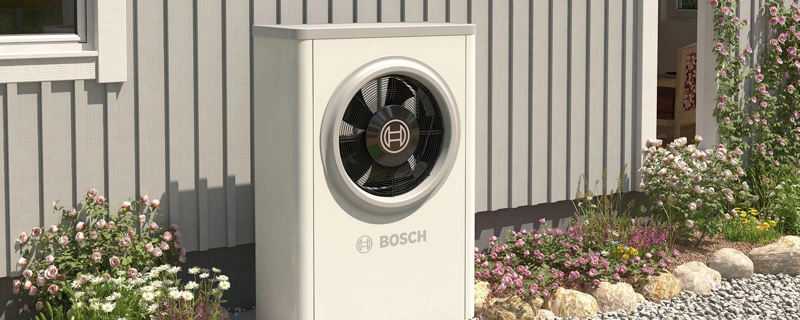Eine Bosch Wärmepumpen Außeneinheit steht vor einem skandinavischen Holzhaus im Gartenbeet