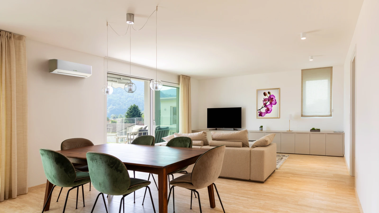 Ein helles Wohnzimmer mit einer hängenden weißen Bosch-Klimaanlage an der Wand.