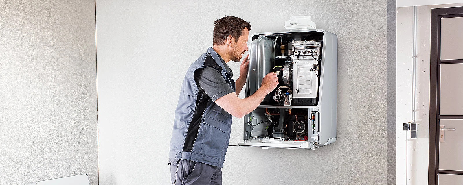 Ein Installateur repariert eine Gastherme.