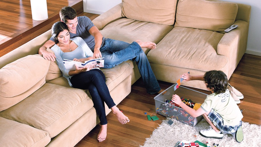 Die Familie sitzt zusammen im Wohnzimmer mit einer komfortablen Wohnraumlüftung