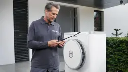 Installateur prüft Betrieb einer Bosch Luft-Wasser-Wärmepumpe