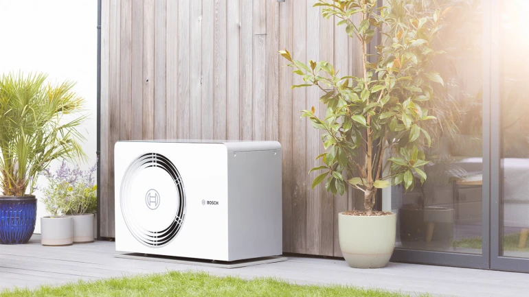 Bosch Wärmepumpe Compress 5800i AW steht an der Hauswand neben der Terrassentür.