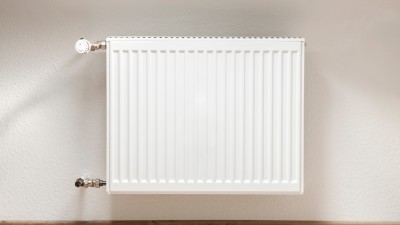Ein Plattenheizkörper an einer weißen Wand hängend Ein Plattenheizkörper an einer weißen Wand hängend