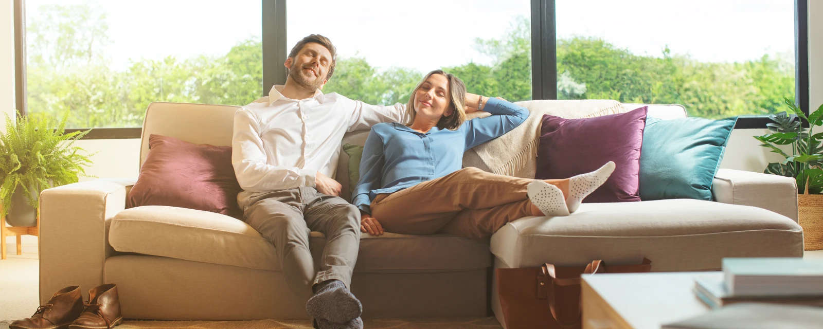 Ein Paar sitzt im Wohnzimmer auf dem Sofa und sieht sehr entspannt aus.