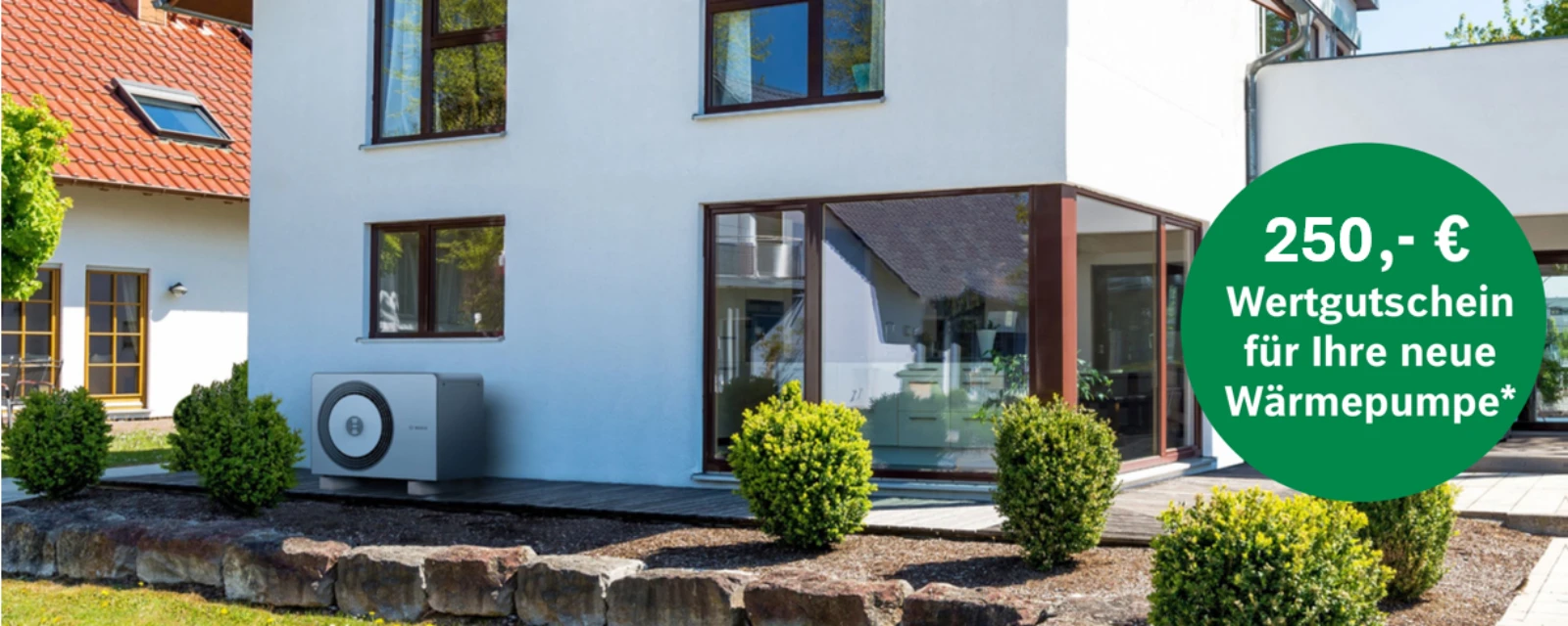 Die Wärmepumpe 5800i AW von Bosch steht an einer Hauswand eines modernen Hauses mit Vorgarten.