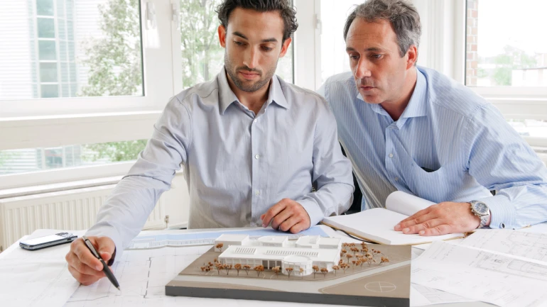 Architekten planen an einem Tisch etwas