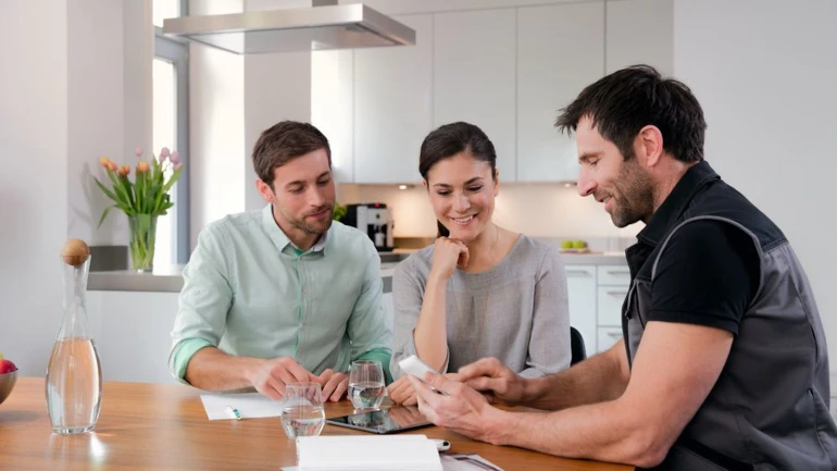 Installateur beratet ein jnges Paar bei der Speicherwahl