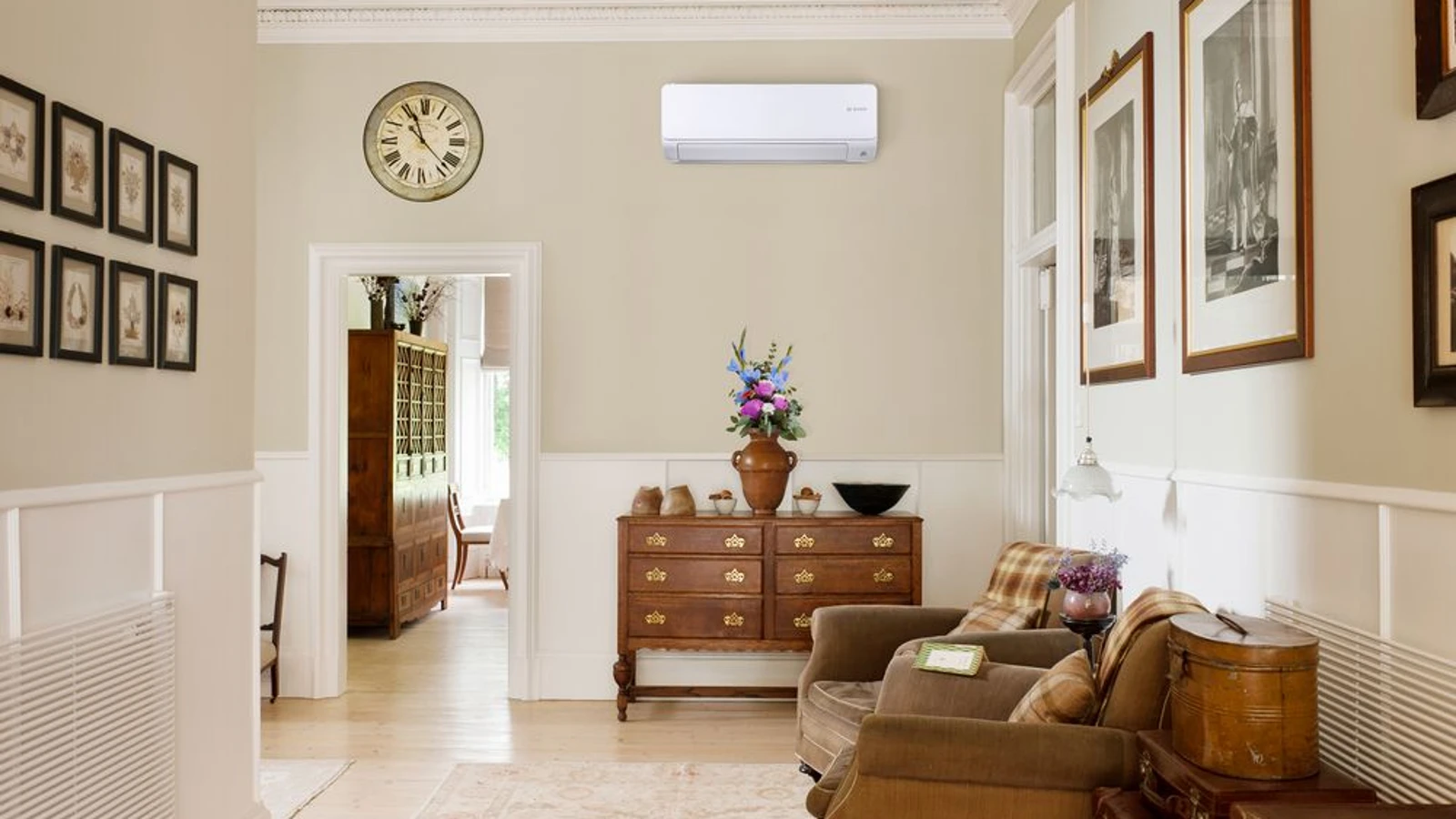 Ein gemütliches Wohnzimmer mit einer Bosch Klimaanlage an der Wand. Moderne Klimageräte sorgen das ganze Jahr für ein angenehmes Raumklima, im Sommer durch Kühlung und im Winter durch effizientes Heizen.