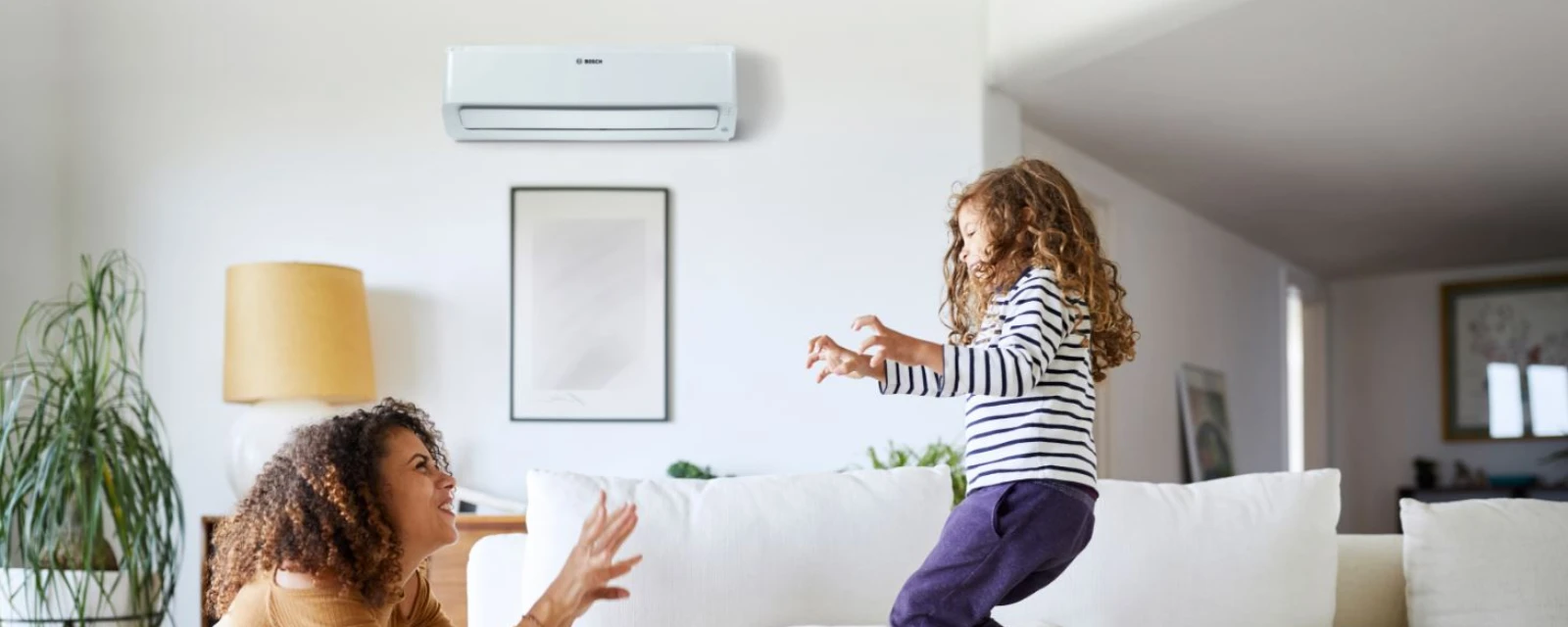 Kind spielt mit seiner Mama im Wohnzimmer