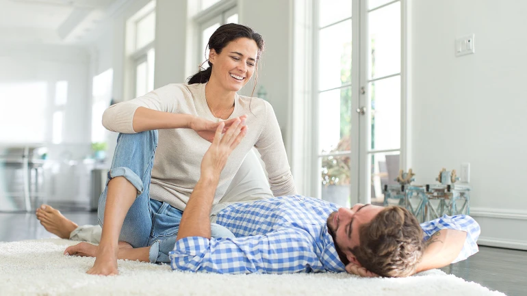 Ein Paar im Wohnzimmer genießt das angenehme Klima dank einer Wohnraumlüftung