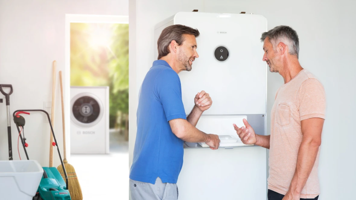 Einbausituation einer Heizung mit zwei Männern.