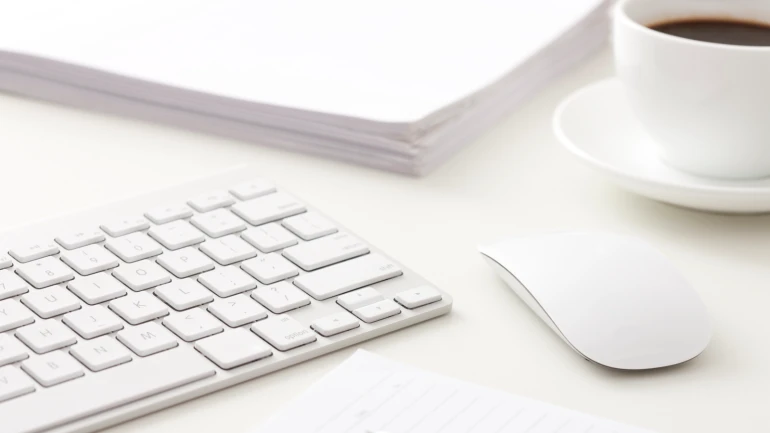 Tastatur mit Maus und im Hintergrund eine Kaffee Tasse
